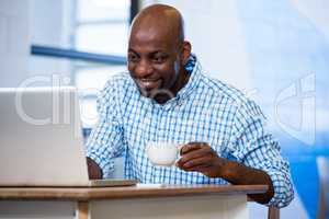 Man using laptop while having coffee