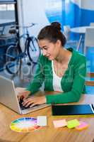 Graphic designer using laptop with graphic tablet on table