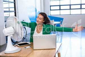 Woman enjoying a breeze with arms outstretched