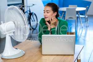 Woman enjoying a breeze while using laptop