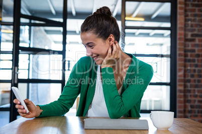 Woman using mobile phone with digital tablet and coffee cup on t