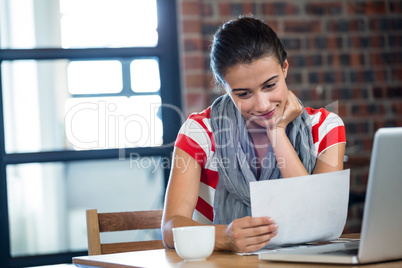 Woman reading a document in office