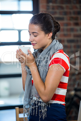 Beautiful woman smelling a cup of coffee