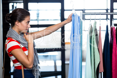 Woman selecting an apparel while shopping for clothes
