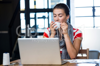 Woman having coffee at desk