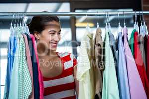 Woman selecting an apparel while shopping for clothes