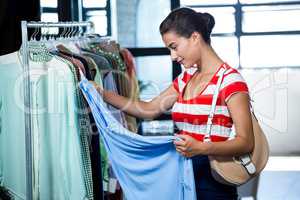 Woman selecting an apparel while shopping for clothes