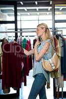 Woman selecting an apparel while shopping for clothes