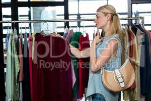 Woman selecting an apparel while shopping for clothes