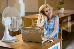 Woman enjoying a breeze while using laptop