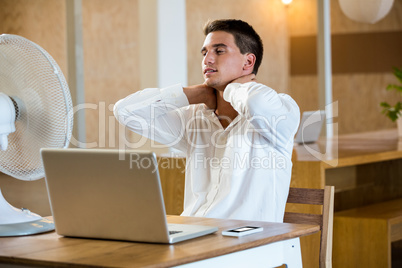 Man enjoying a breeze while using laptop