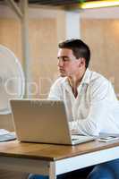 Man enjoying a breeze while using laptop
