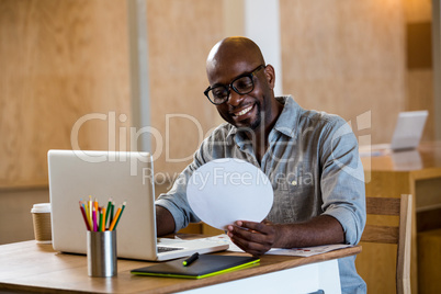 Graphic designer using laptop in office