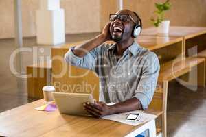 Laughing man with headphones sitting at table