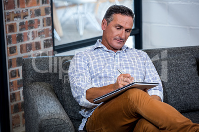 Man writing note on diary