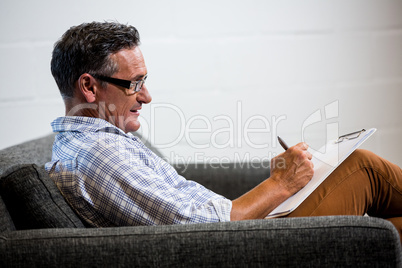 Man writing note on clipboard