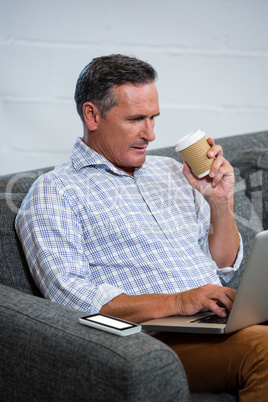 Man using laptop while having coffee