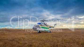 Helicopter taking off in a field