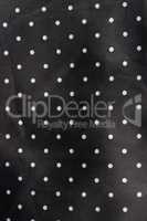 black fabric background with white dots