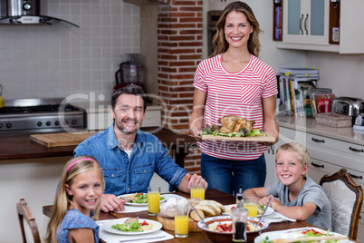 Woman serving food to her family in the kitchen