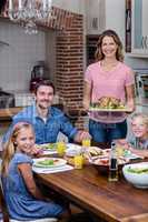 Woman serving food to her family in the kitchen