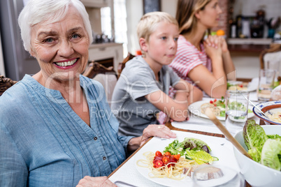 Portrait of senior woman having meal with her family