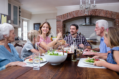 Woman serving food to her family in the kitchen