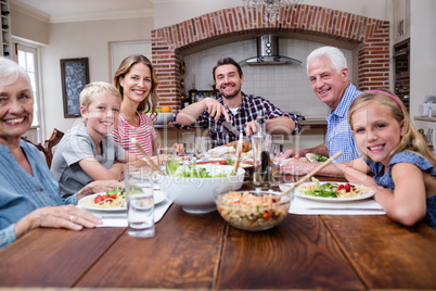 Man cutting roasted turkey while having meal with his family