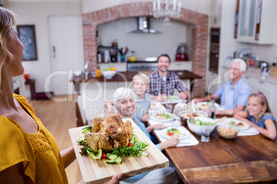 Woman holding a tray of roasted turkey