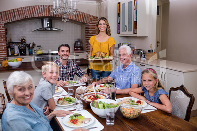 Woman serving food to her family in the kitchen