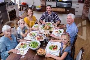 Portrait of multi-generation family having meal in kitchen