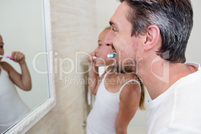 Father and daughter brushing their teeth in the bathroom Father and daughter brushing their teeth in the bathroom