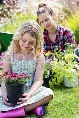 Girl sitting in garden with flower pot