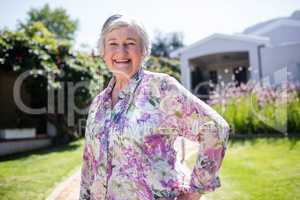 Portrait of happy senior woman standing in garden