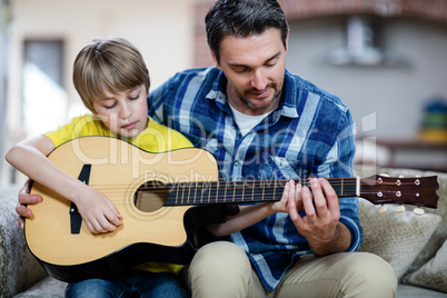 Father and son playing a guitar Father and son playing a guitar