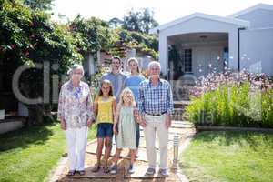 Multi-generation family standing on the garden path