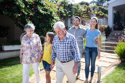 Multi-generation family walking on the garden path