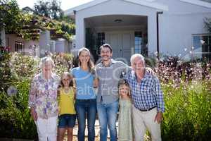 Multi-generation family standing on the garden path