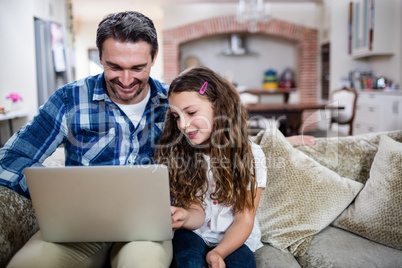 Father and daughter using laptop