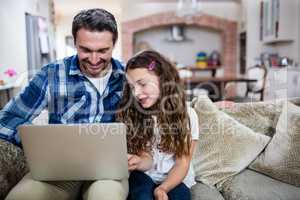 Father and daughter using laptop