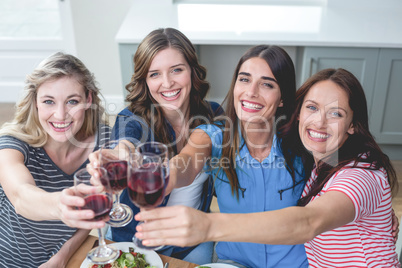 Friends toasting glass of wine while having meal