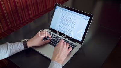 Man typing on laptop Macbook computer