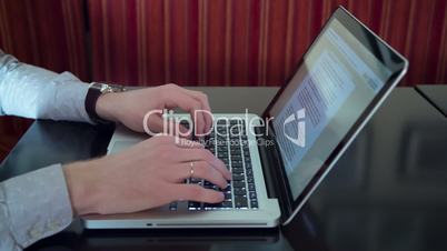 Man typing on laptop Macbook computer