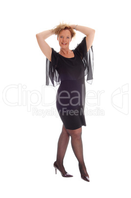 Happy woman in black dress standing.