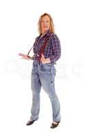 A blond woman standing in jeans and suspender.