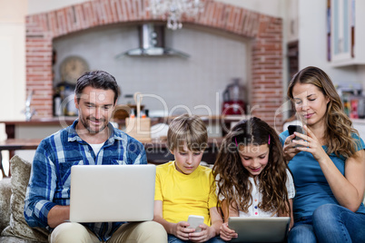 Parents and kids using a laptop, tablet and phone