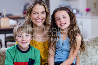 Portrait of happy mother and kids sitting on a sofa