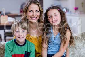 Portrait of happy mother and kids sitting on a sofa