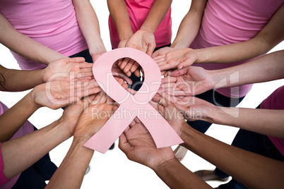 Women in pink outfits standing in a circle for breast cancer awa