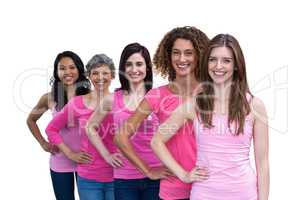 Smiling women in pink outfits posing for breast cancer awareness